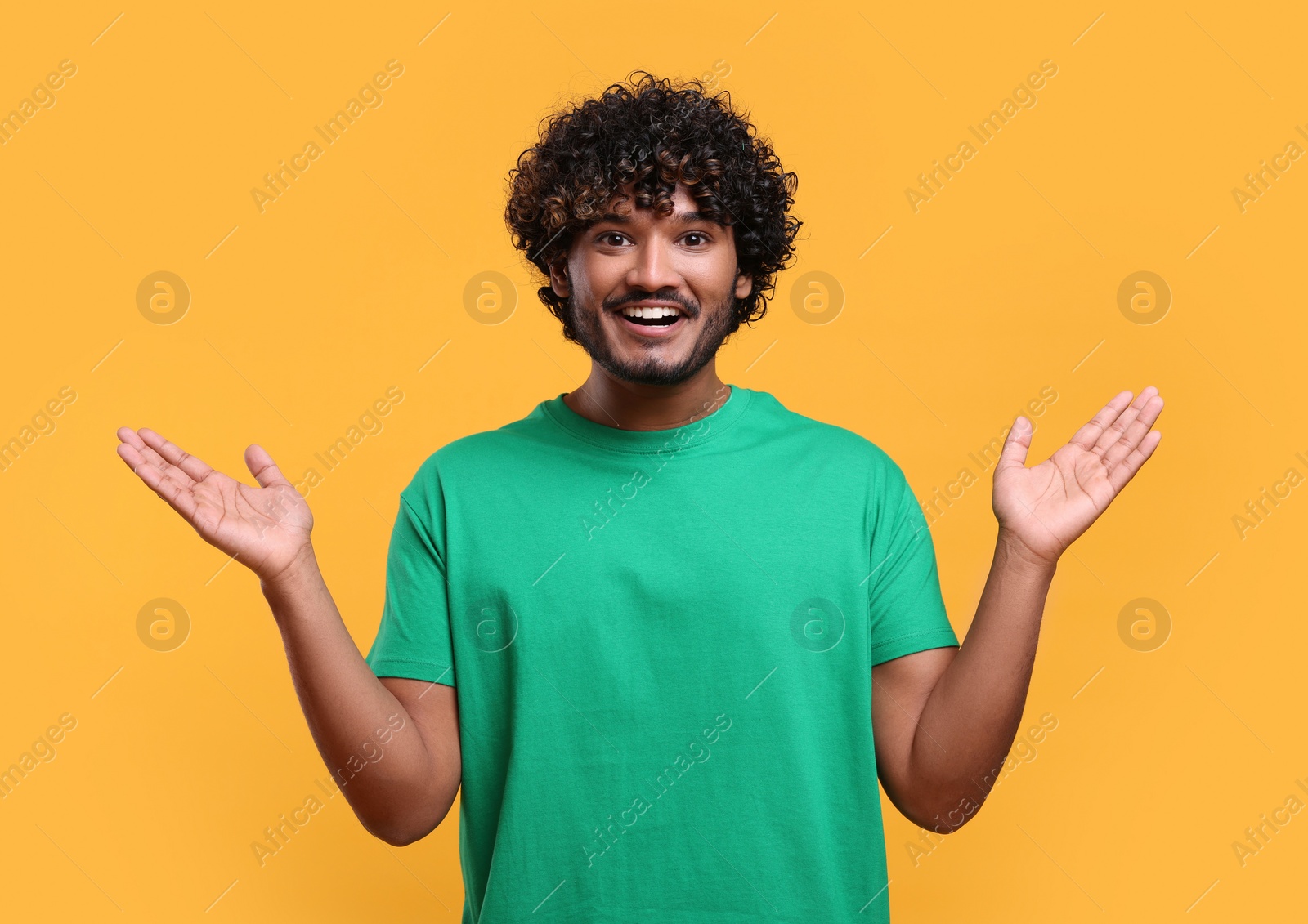 Photo of Handsome young smiling man on yellow background