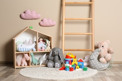 Different child toys on floor against color wall