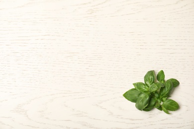 Fresh basil leaves on wooden background, top view. Space for text