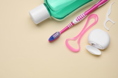 Photo of Tongue cleaner and other oral care products on beige background, flat lay. Space for text