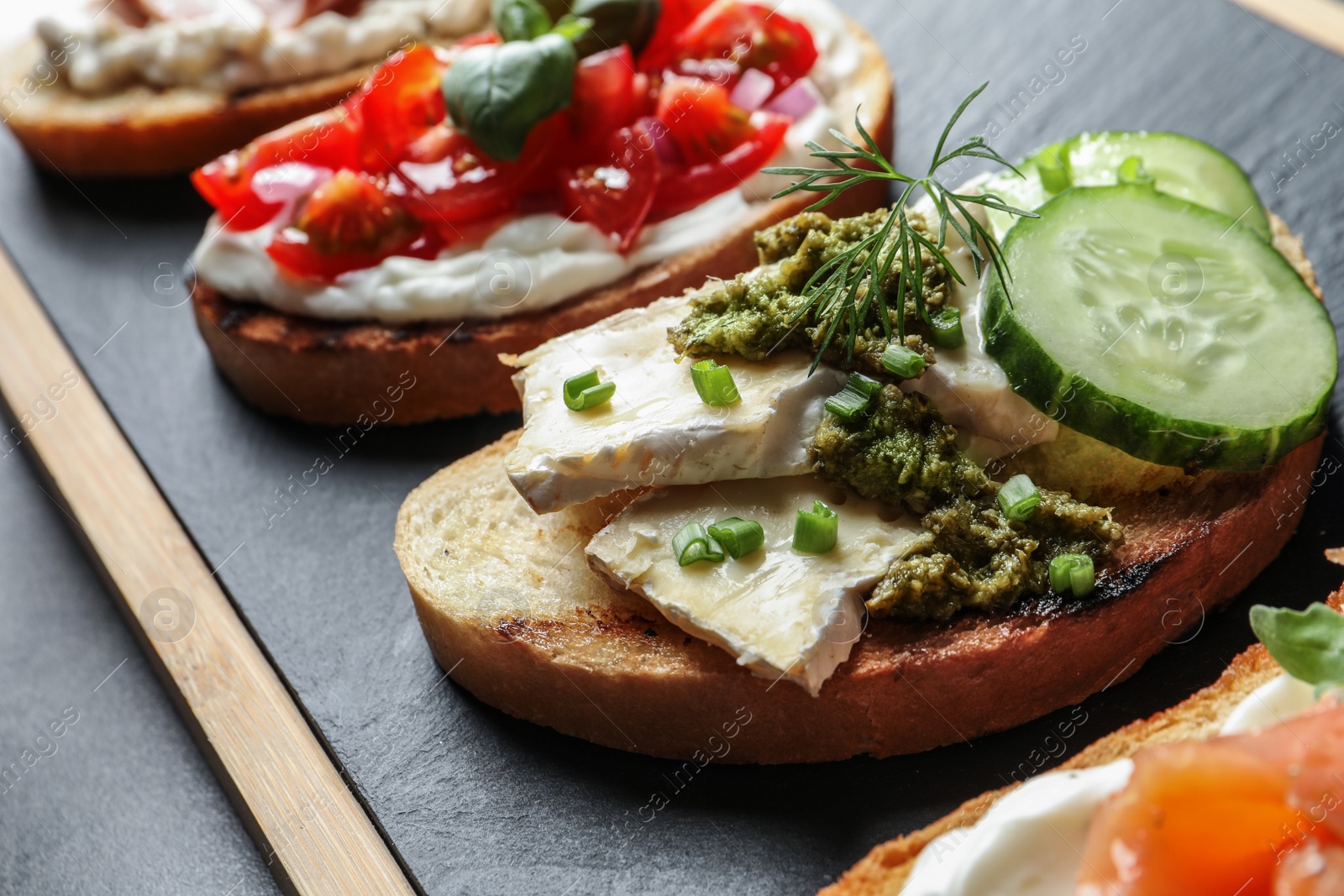 Photo of Board with different tasty bruschettas on table, closeup