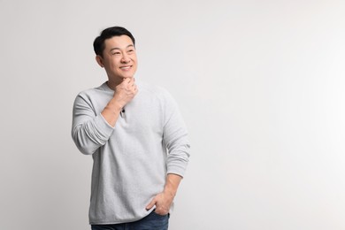 Portrait of happy man on light background. Space for text