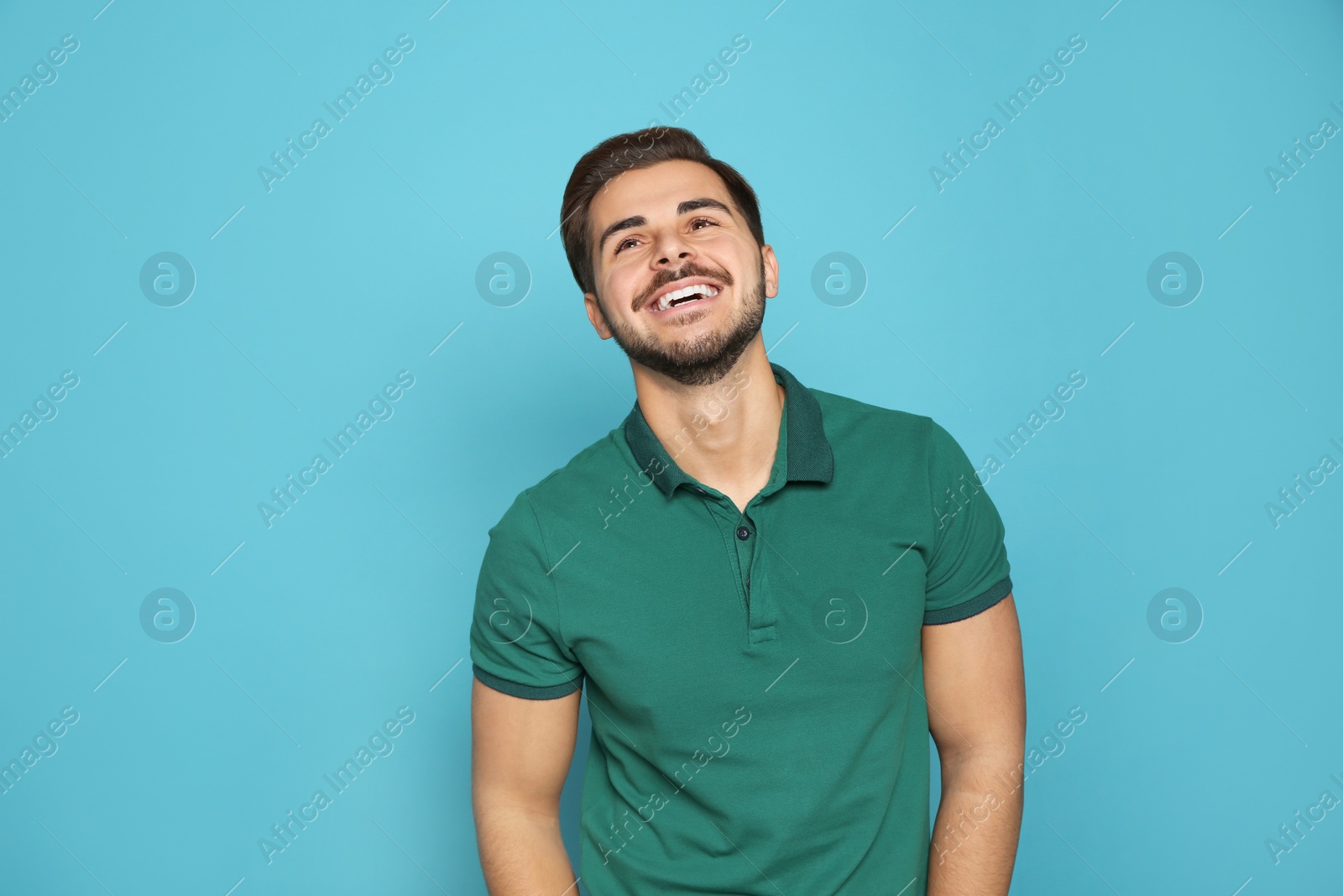 Photo of Portrait of young man laughing on color background