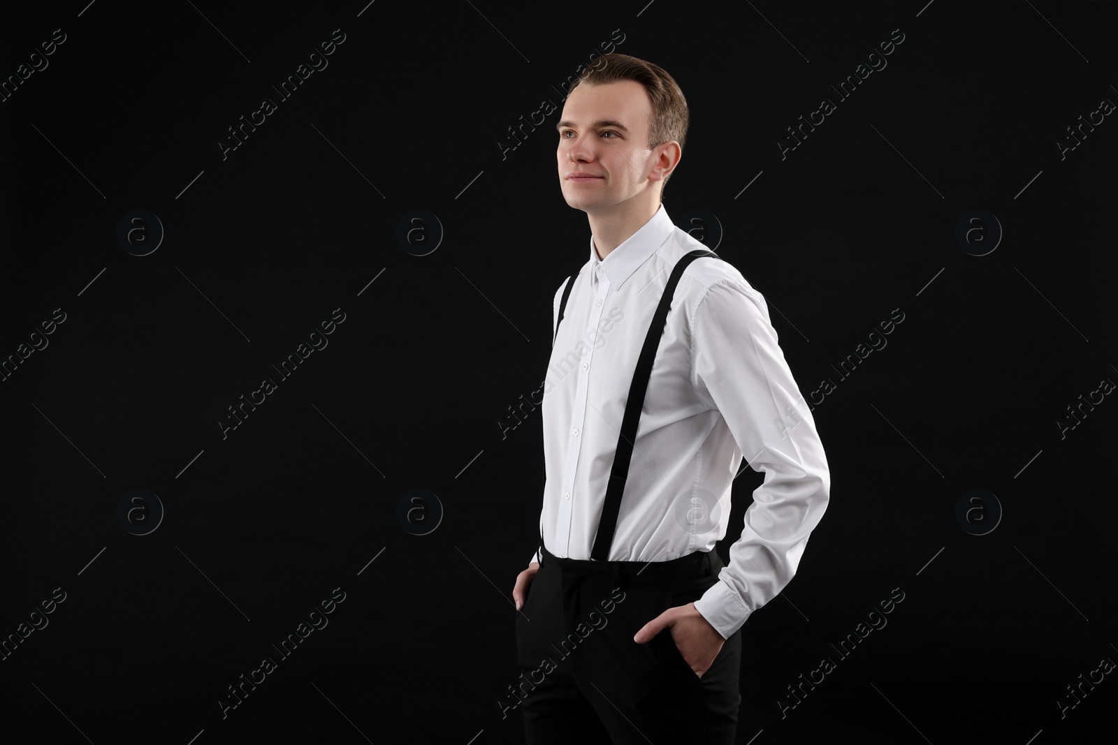 Photo of Handsome young man in white shirt on black background, space for text