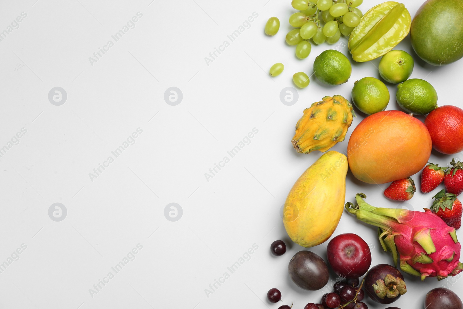 Photo of Many different delicious exotic fruits on light background, flat lay. Space for text