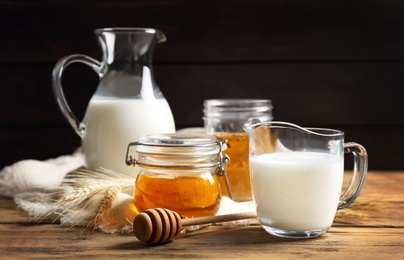 Beautiful composition with milk and honey on wooden table