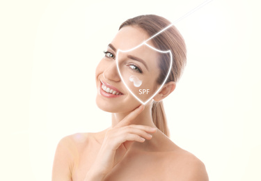 Image of SPF shield and beautiful young woman with healthy skin on light background. Sun protection cosmetic product
