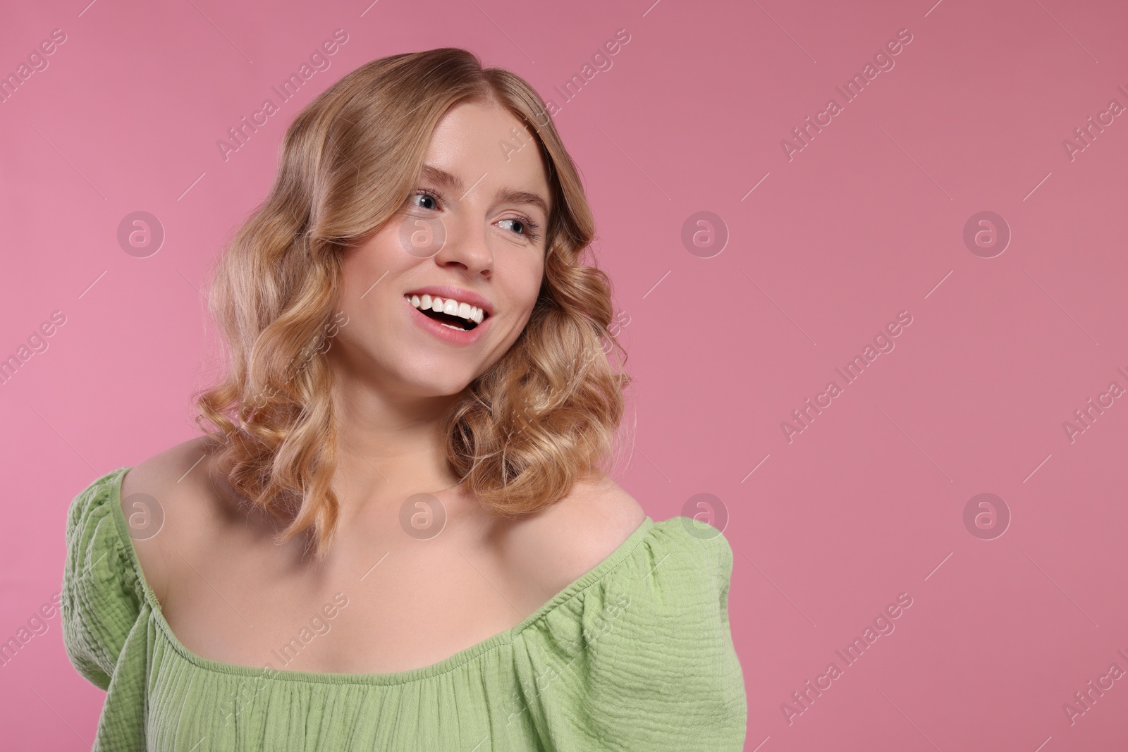 Photo of Portrait of beautiful woman with blonde hair on pink background