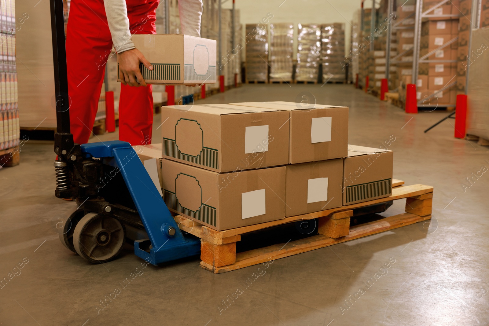 Image of Worker taking cardboard box from pallet in warehouse, closeup