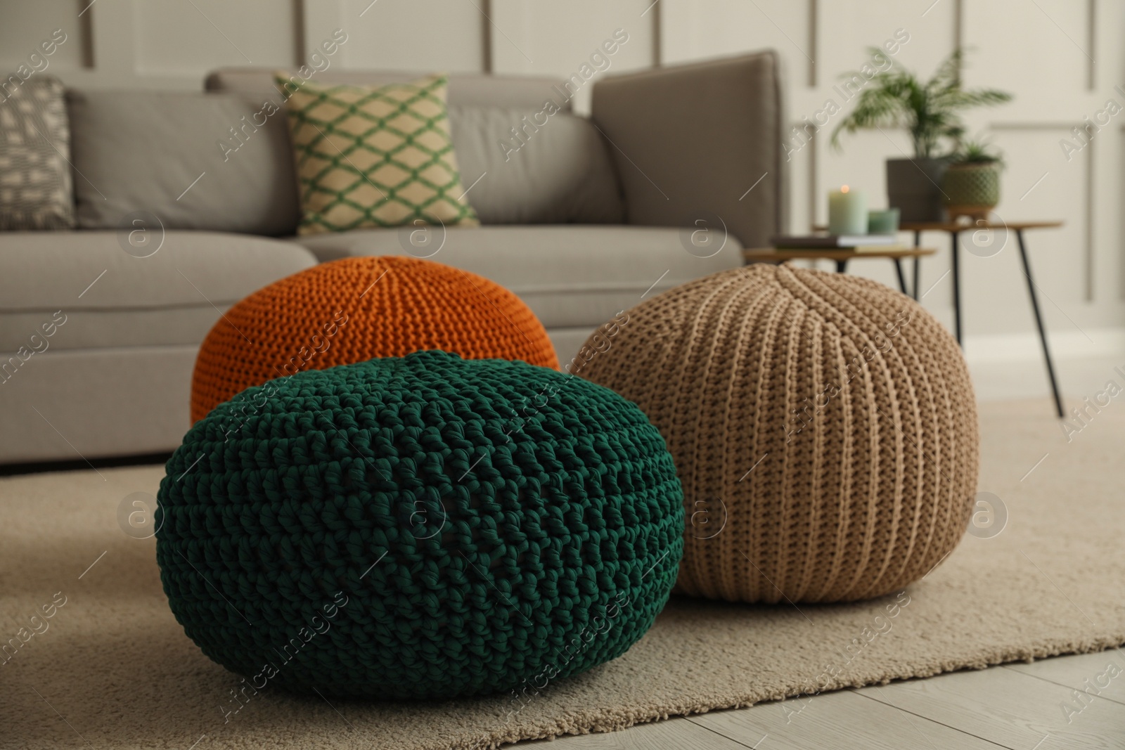 Photo of Living room interior with different stylish knitted poufs and sofa