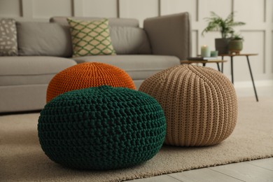 Living room interior with different stylish knitted poufs and sofa