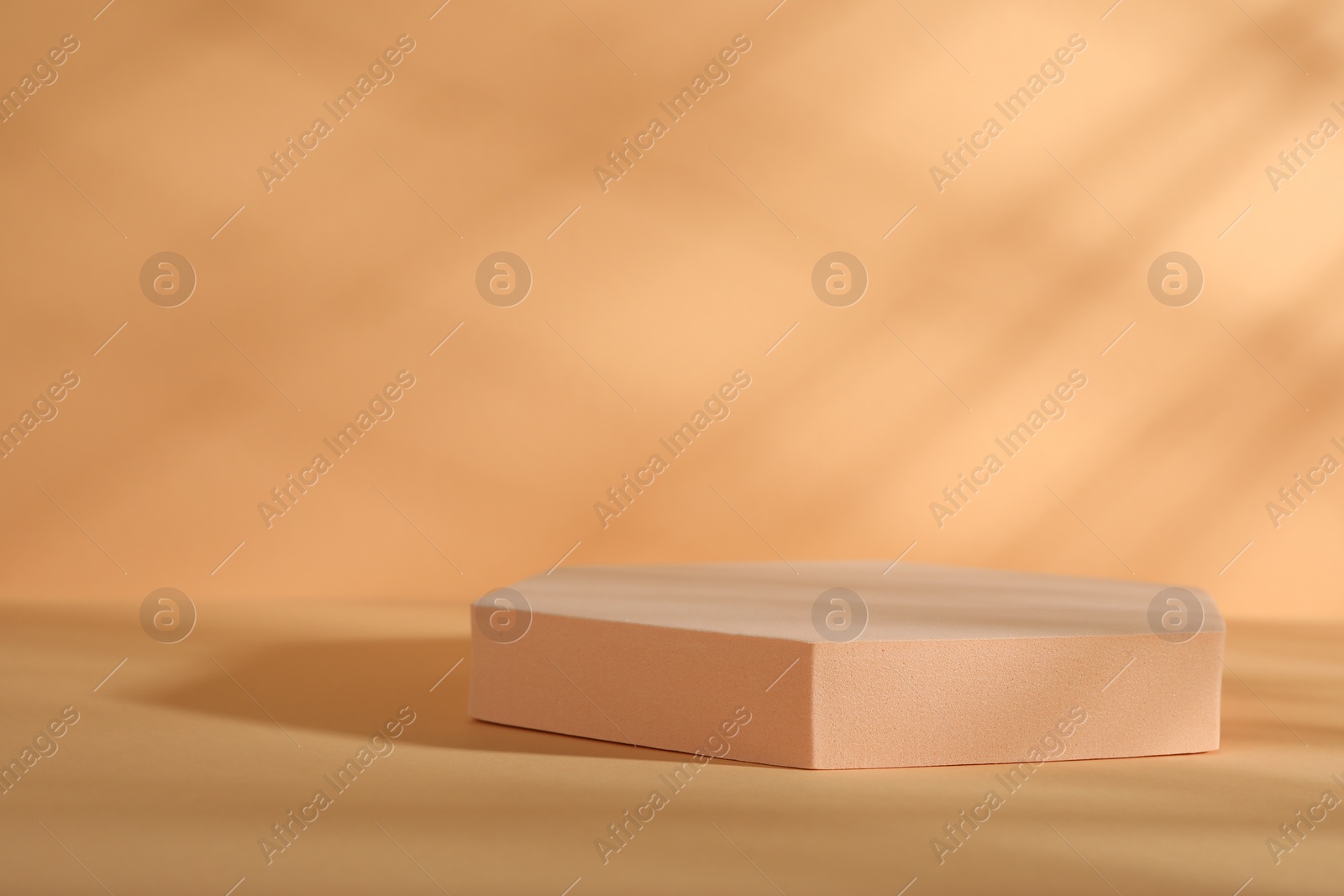 Photo of Presentation of product. Podium and shadows on orange background. Space for text