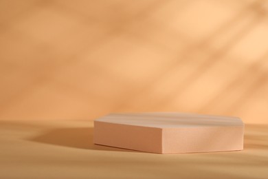 Photo of Presentation of product. Podium and shadows on orange background. Space for text