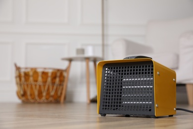 Modern electric heater on floor at home. Space for text