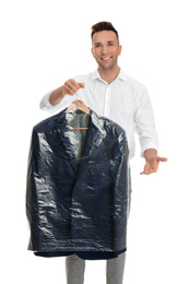 Man holding hanger with jacket in plastic bag on white background. Dry-cleaning service