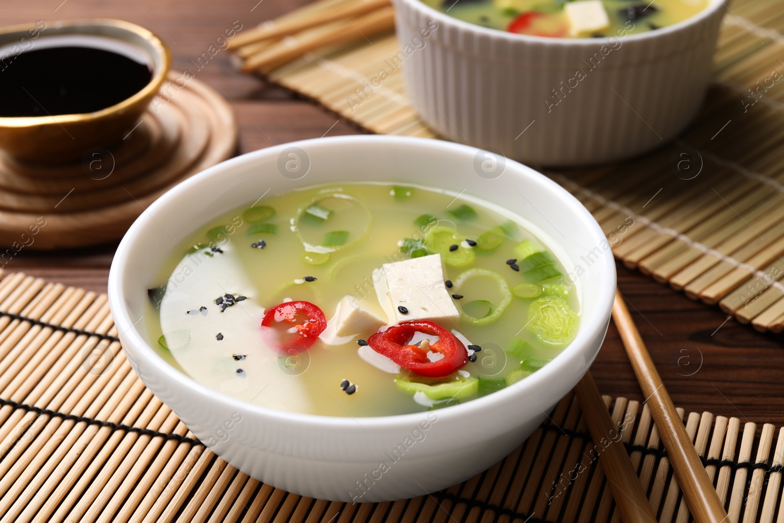 Photo of Bowl of delicious miso soup with tofu served on wooden table