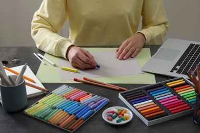 Artist drawing with soft pastels at table indoors, closeup