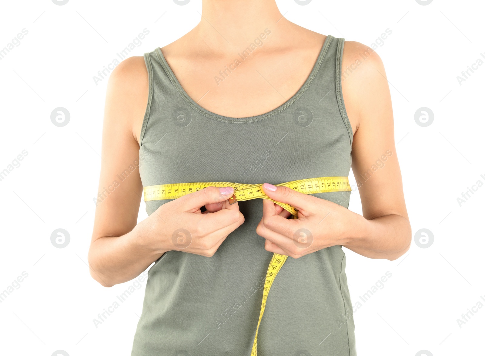 Photo of Young woman measuring breast size on white background, closeup. Cosmetic surgery