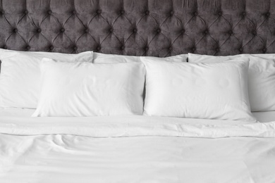 Soft white pillows on comfortable bed, closeup