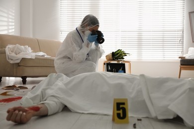 Photo of Investigator working at crime scene with dead body