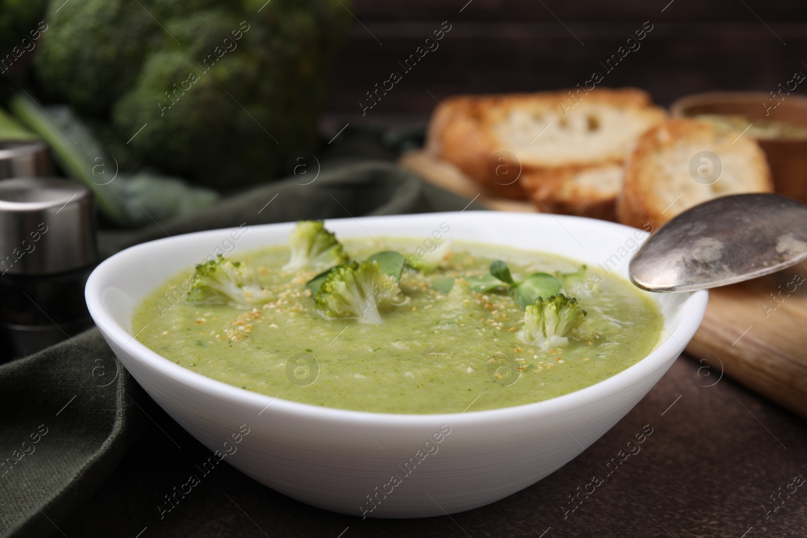 Photo of Delicious broccoli cream soup served on grey table, closeup