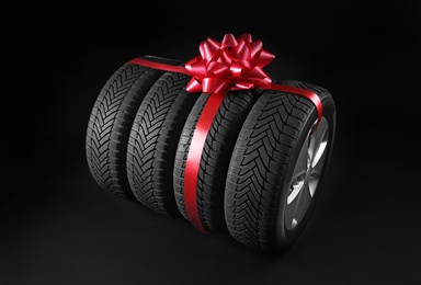 Gift set of wheels with winter tires on black background