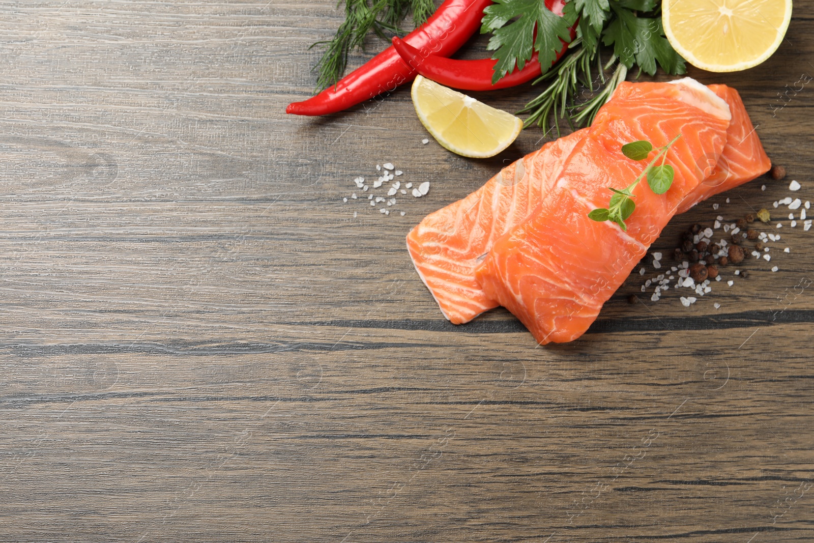 Photo of Fresh salmon and ingredients for marinade on wooden table, flat lay. Space for text