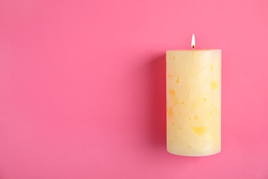 Photo of Alight wax candle and space for text on color background