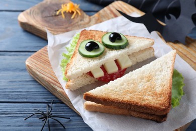 Cute monster sandwich served on blue wooden table, closeup. Halloween party food