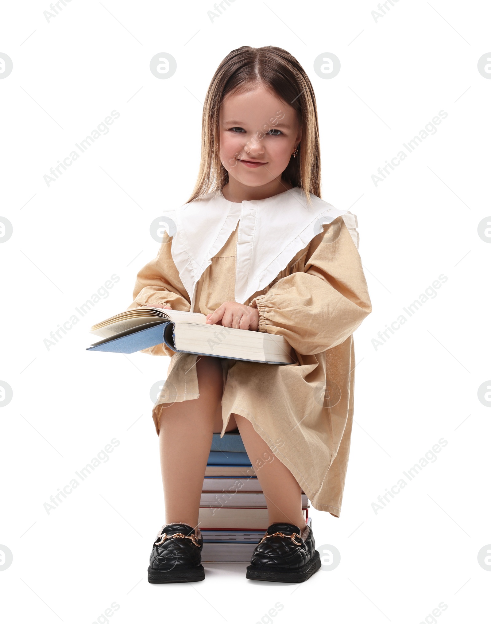 Photo of Cute little girl sitting on stack of books against white background