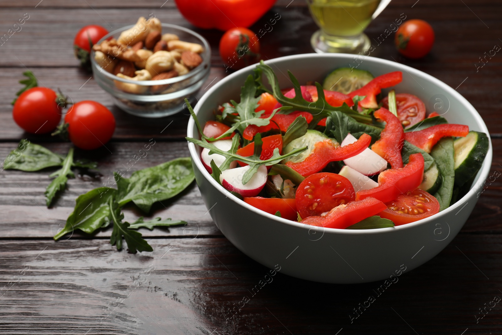 Photo of Tasty fresh vegetarian salad on dark wooden table