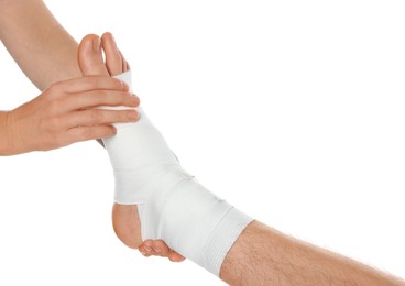 Photo of Doctor examining patient's foot wrapped in medical bandage on white background, closeup