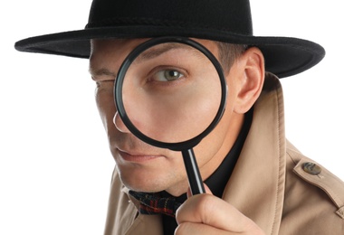 Male detective looking through magnifying glass on white background