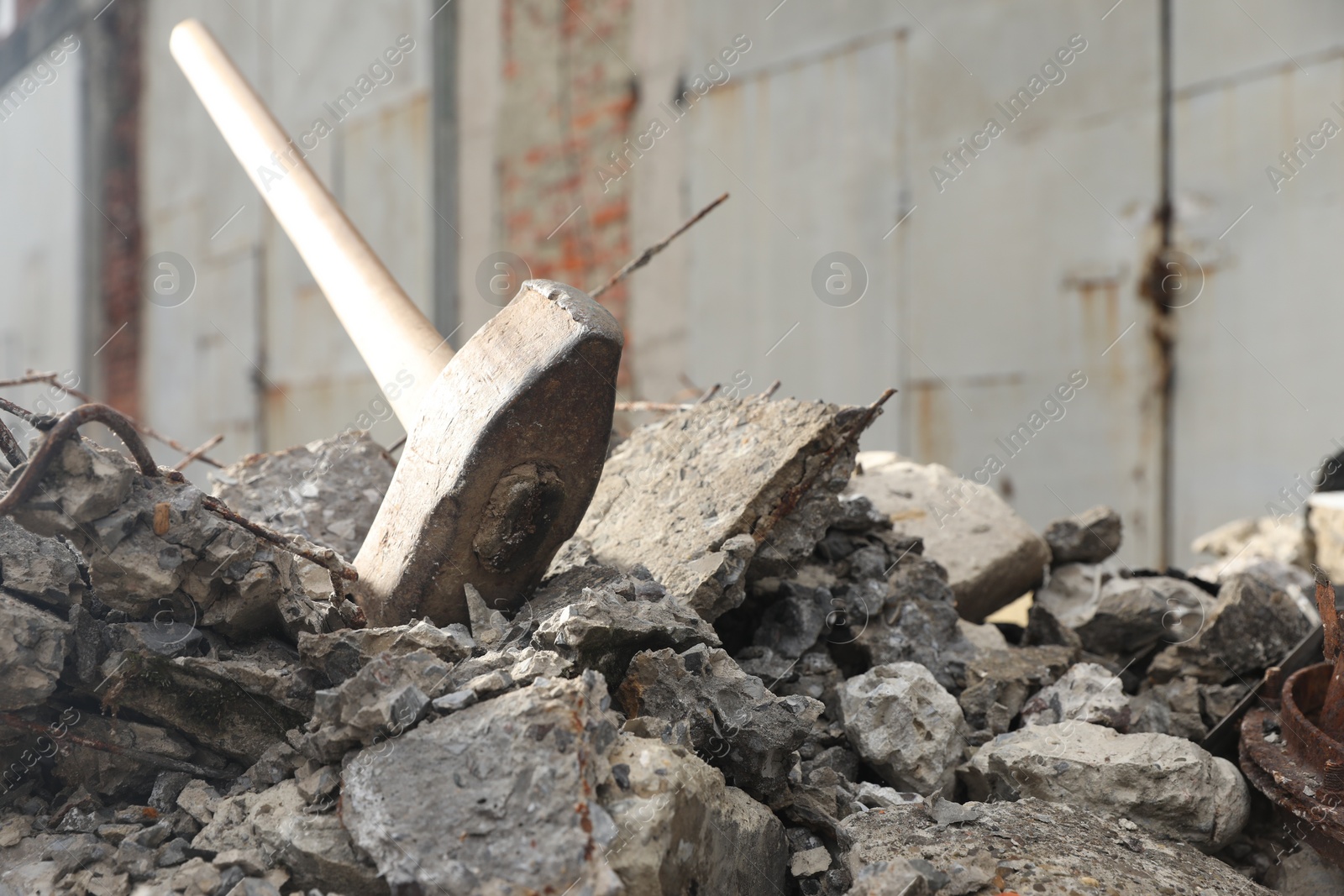 Photo of Sledgehammer on pile of broken stones outdoors, closeup