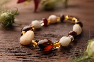Beautiful bracelet with gemstones on wooden table, closeup