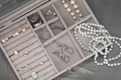 Jewelry box with many different accessories on grey table, top view