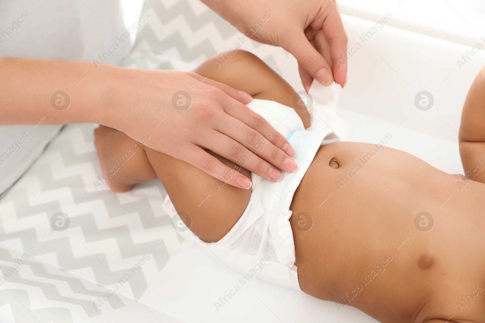 Photo of Mother changing her baby's diaper on table, closeup