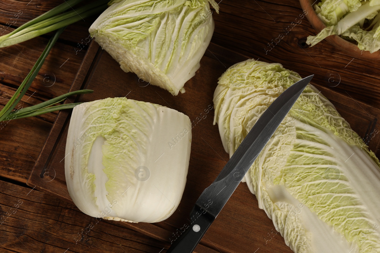 Photo of Whole and cut fresh Chinese cabbages on wooden table, flat lay