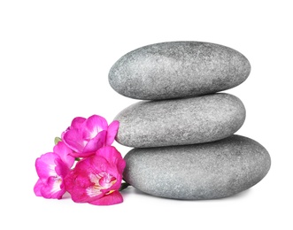 Photo of Stack of spa stones and beautiful flowers on white background