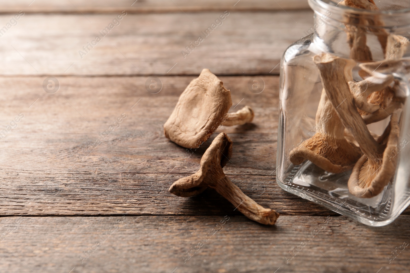 Photo of Composition of dried mushrooms and glassware on table, closeup. Space for text