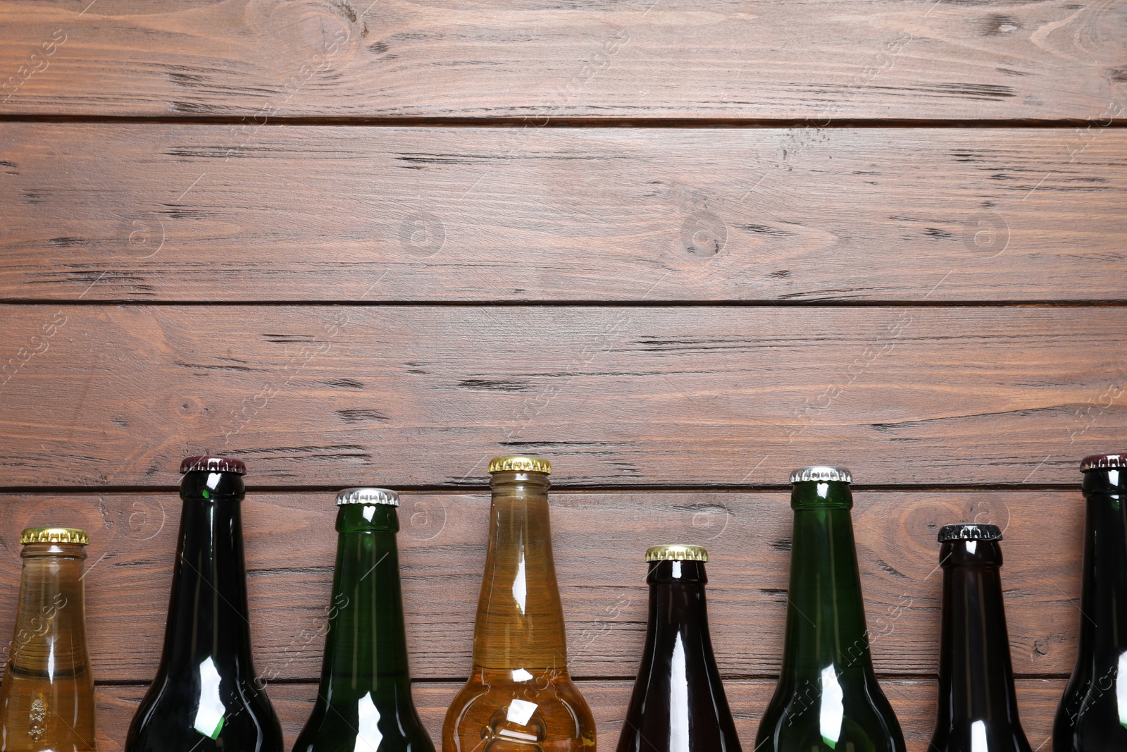 Photo of Bottles with different types of beer on wooden background