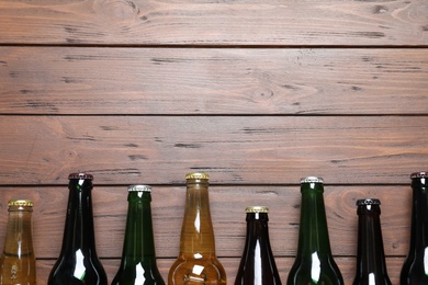 Photo of Bottles with different types of beer on wooden background