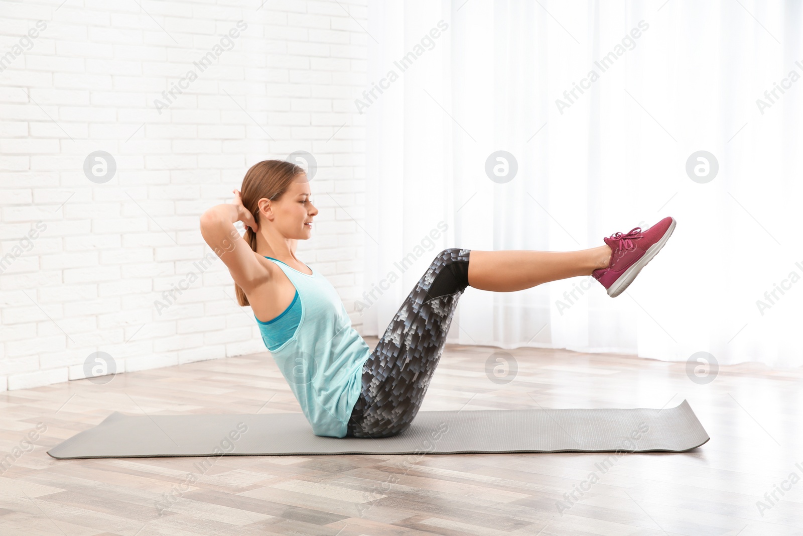 Photo of Young woman doing fitness exercises at home