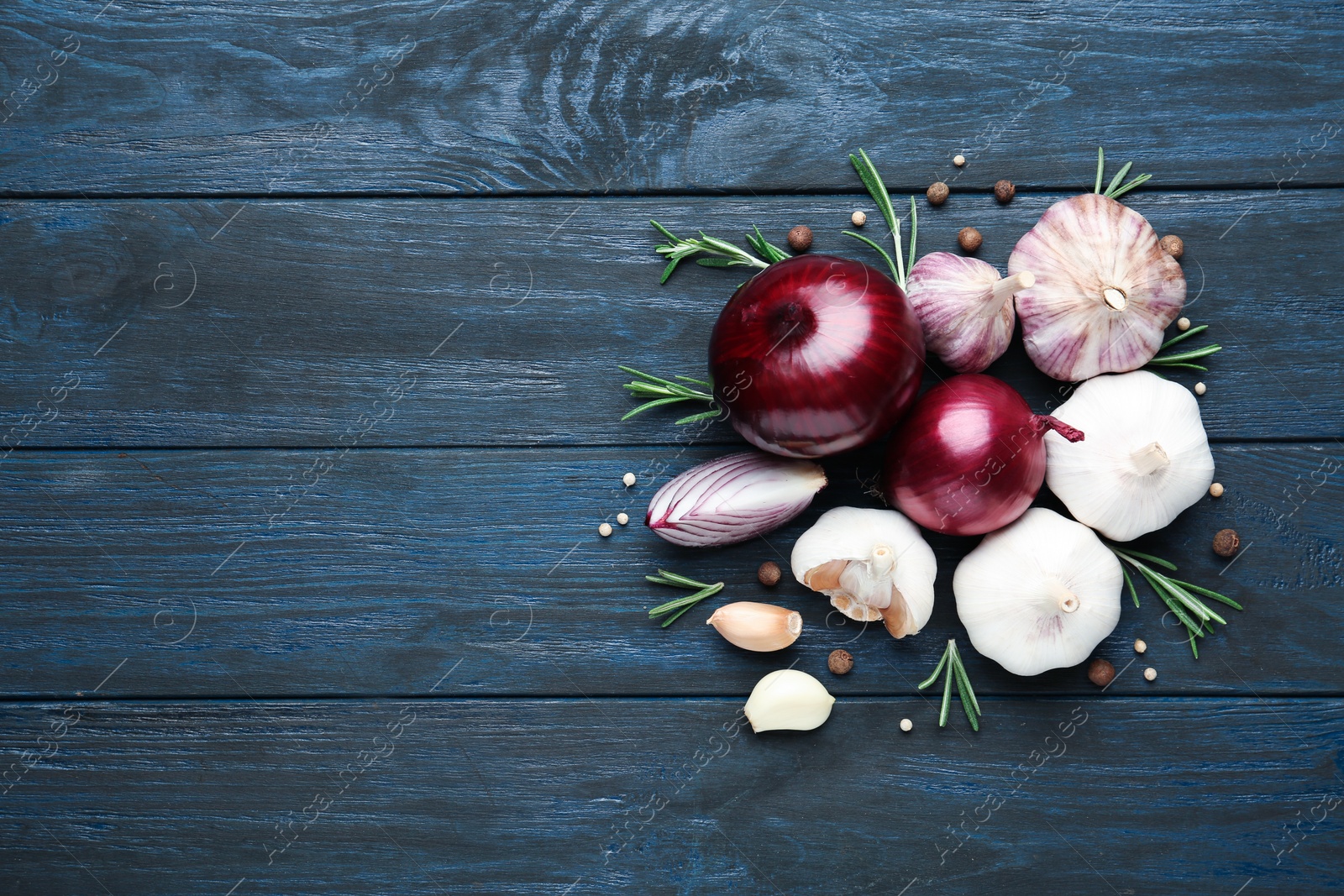 Photo of Flat lay composition with garlic, onions and space for text on wooden background