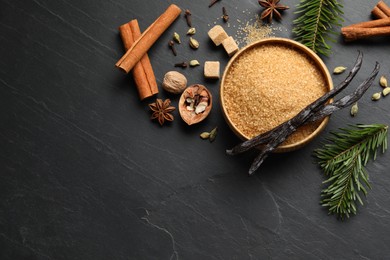 Photo of Different aromatic spices and fir branches on dark textured table, flat lay. Space for text