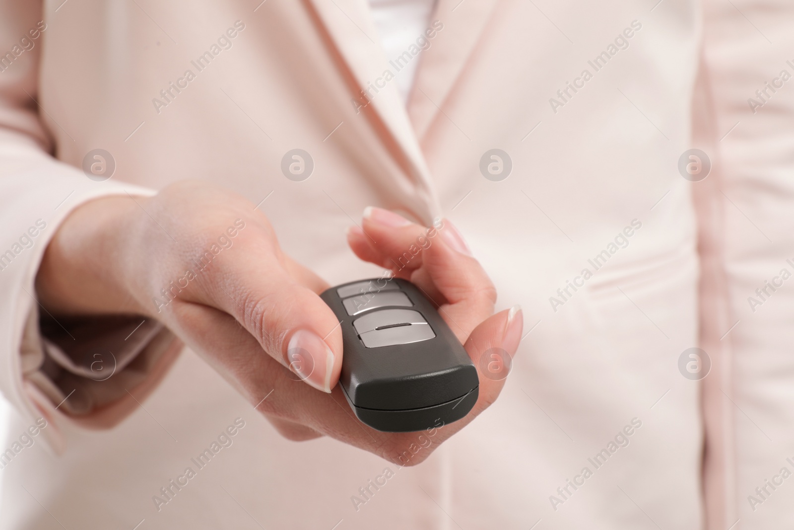 Photo of Young woman holding car smart key, closeup view