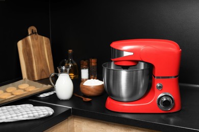 Photo of Modern red stand mixer and ingredients on countertop in kitchen