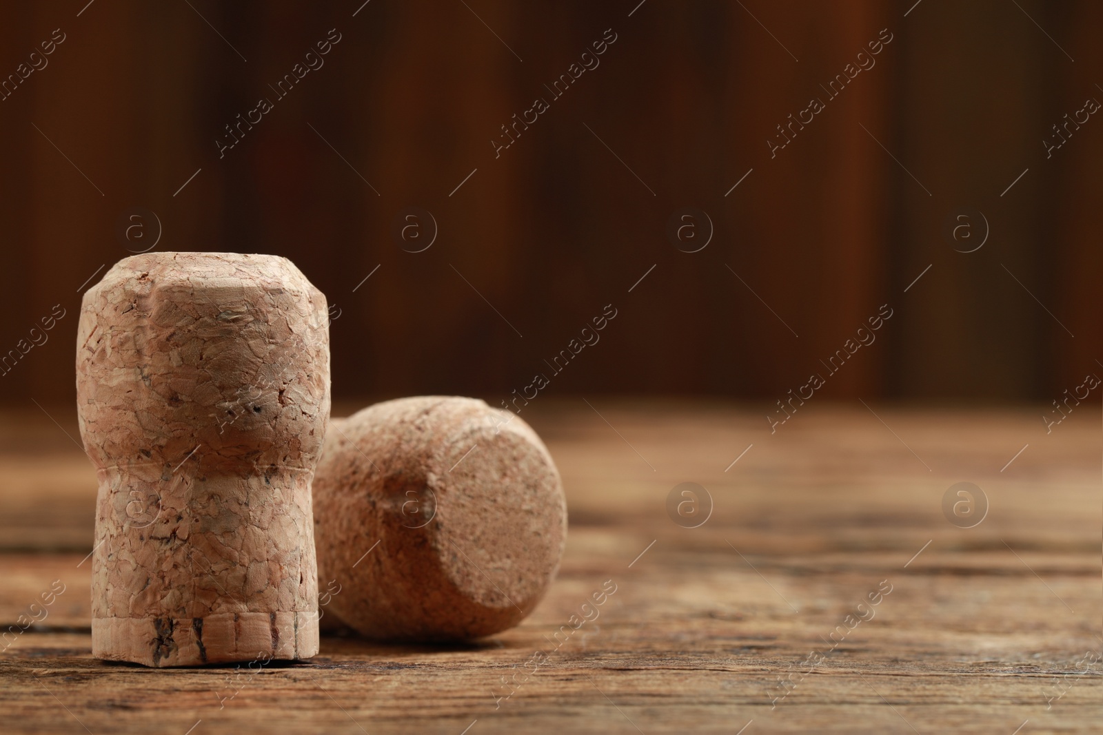 Photo of Corks of wine bottles on wooden table, closeup. Space for text
