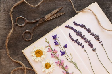 Photo of Flat lay composition with beautiful dried flowers and book on wooden table