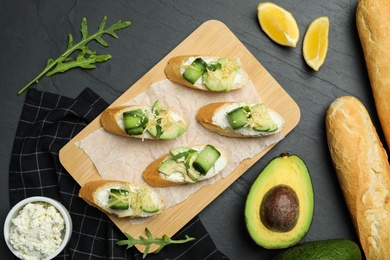 Photo of Flat lay composition with avocado sandwiches on dark grey table